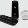 The Fitbit One shown compared to a coin