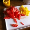 Fresh Salad Addiction Red and yellow peppers sliced on a white chopping board