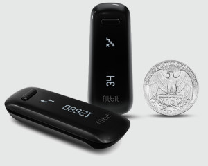 The Fitbit One shown compared to a coin