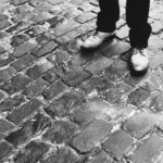 Man in shoes standing on cobblestones