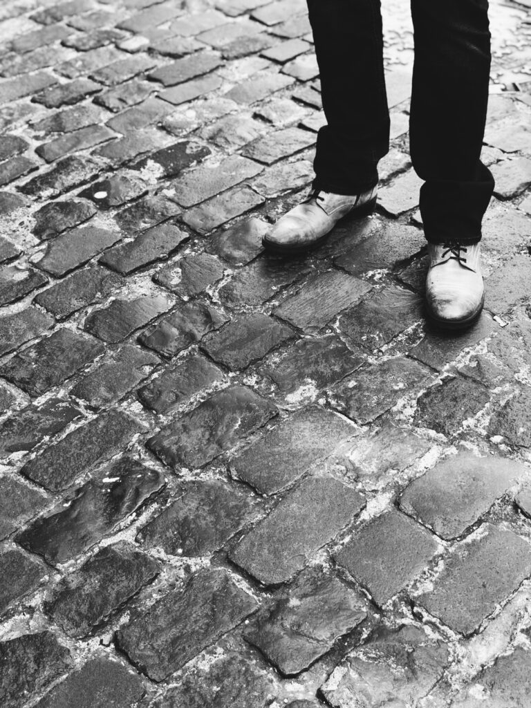 Man in shoes standing on cobblestones